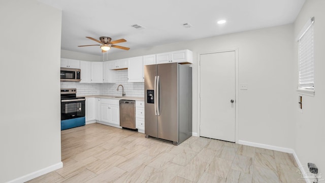 kitchen with ceiling fan, sink, white cabinetry, and stainless steel appliances