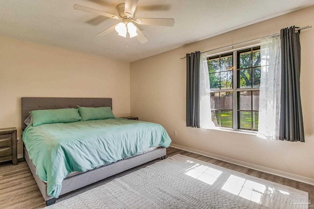 bedroom featuring ceiling fan, a textured ceiling, and hardwood / wood-style floors