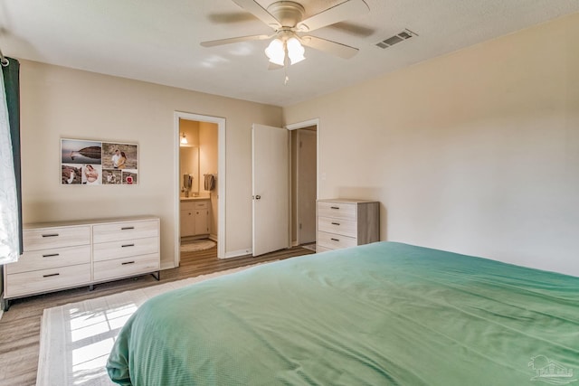 bedroom featuring ceiling fan, light wood-type flooring, and ensuite bath