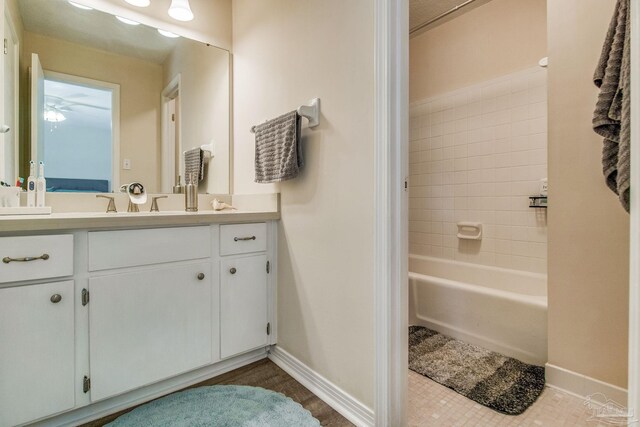 bathroom with tile patterned flooring, tiled shower / bath combo, and vanity