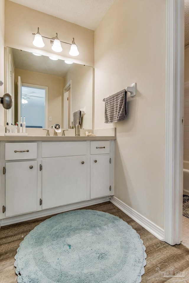 bathroom with hardwood / wood-style flooring, vanity, and a textured ceiling