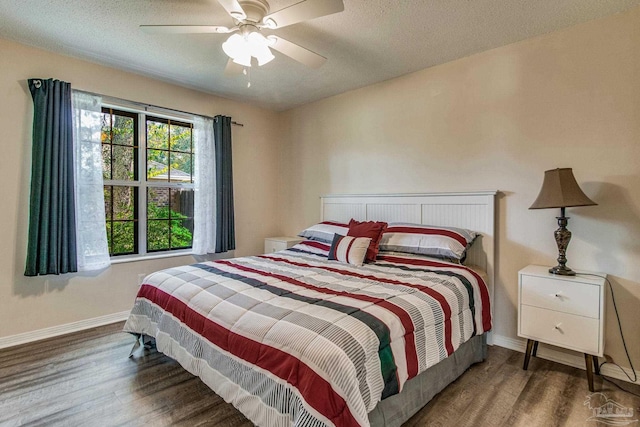 bedroom with dark hardwood / wood-style flooring, a textured ceiling, and ceiling fan