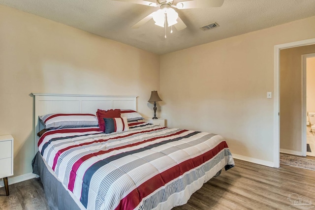 bedroom featuring ceiling fan, hardwood / wood-style floors, and a textured ceiling