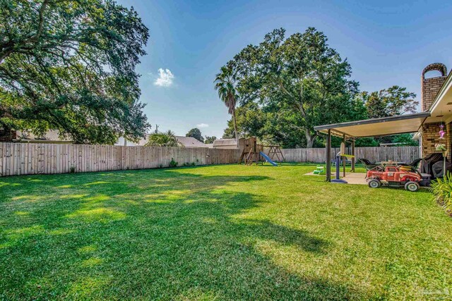 view of yard featuring a playground and a patio