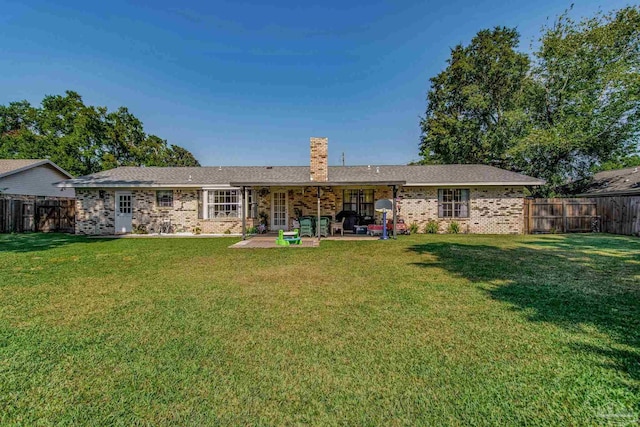 back of house featuring a patio and a lawn