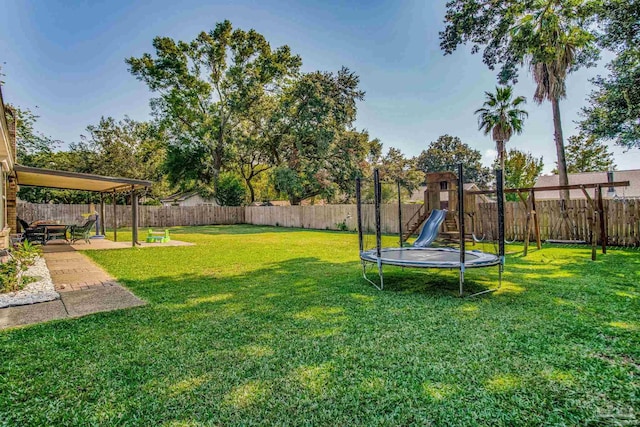 view of yard featuring a trampoline and a patio area