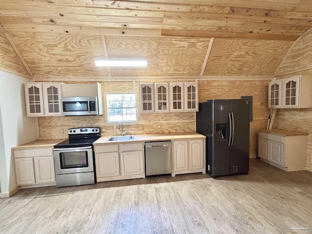 kitchen with appliances with stainless steel finishes, light wood-style floors, light countertops, and a sink