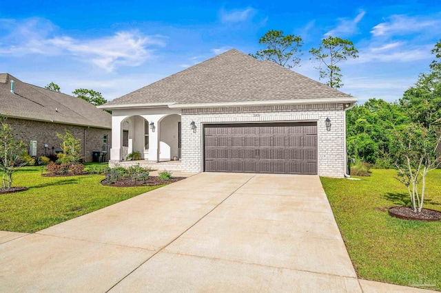 3209 Mountain Laurel Trl, Cantonment, FL 32533 - french country home featuring a front lawn, a garage, roof with shingles, brick siding, and driveway