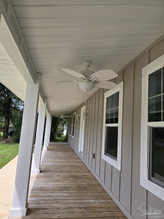 wooden terrace featuring covered porch and ceiling fan