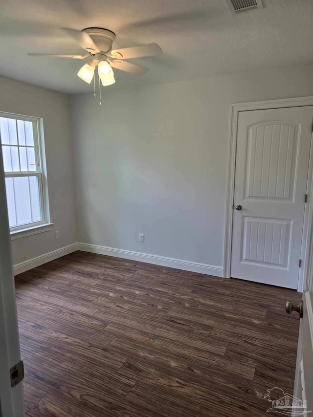 spare room featuring dark hardwood / wood-style floors and ceiling fan