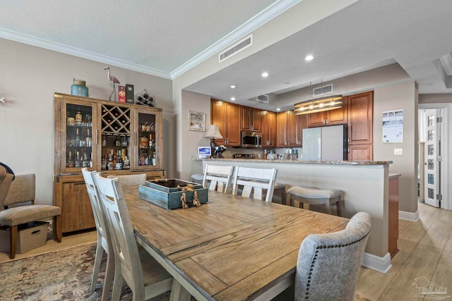 616 Lost Key Dr Unit 902A, Perdido Key, FL 32507 - dining area featuring light wood-style flooring, crown molding, a textured ceiling, baseboards, and recessed lighting