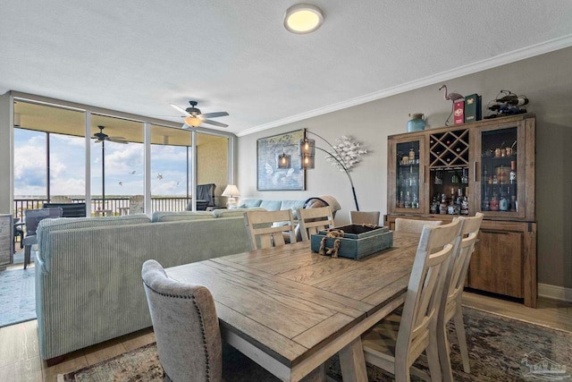616 Lost Key Dr Unit 902A, Perdido Key, FL 32507 - dining area featuring a textured ceiling, a ceiling fan, ornamental molding, healthy amount of natural light, and light wood-style floors