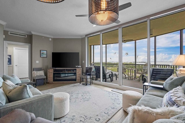 616 Lost Key Dr Unit 902A, Perdido Key, FL 32507 - living room with a ceiling fan, wood finished floors, healthy amount of natural light, crown molding, and a glass covered fireplace