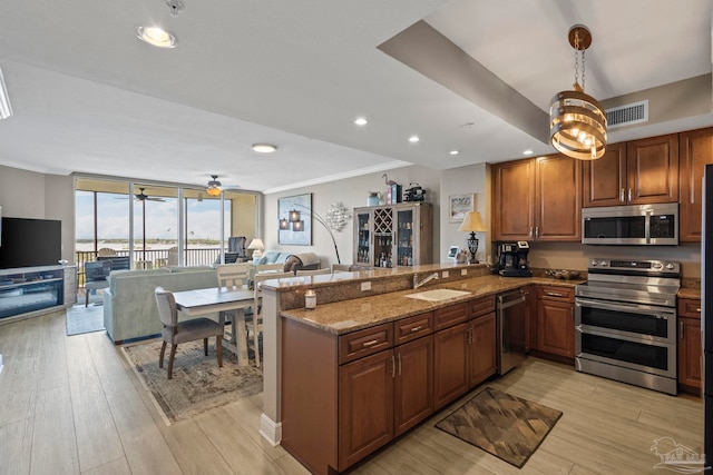 616 Lost Key Dr Unit 902A, Perdido Key, FL 32507 - kitchen featuring appliances with stainless steel finishes, a sink, open floor plan, a wall of windows, and light wood-style flooring