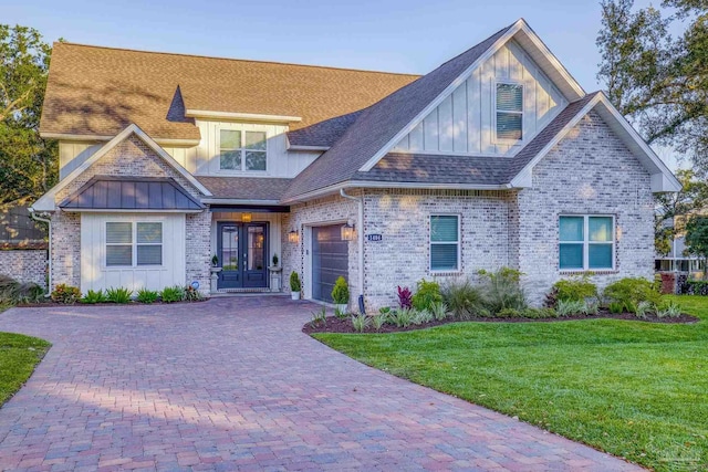 craftsman-style home featuring a garage, a front yard, and french doors