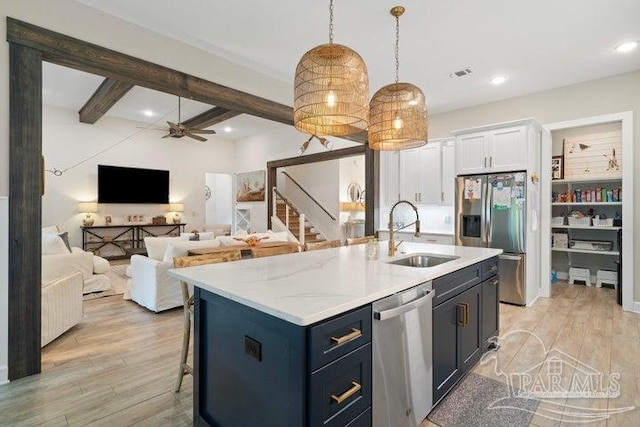 kitchen with stainless steel appliances, ceiling fan, sink, white cabinetry, and hanging light fixtures