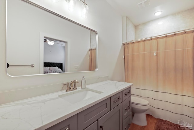 bathroom featuring hardwood / wood-style flooring, vanity, ceiling fan, and toilet