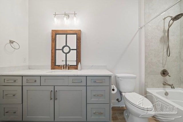 full bathroom featuring tile patterned flooring, toilet, vanity, and tiled shower / bath