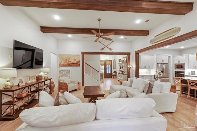 living room featuring beamed ceiling, french doors, light wood-type flooring, and ceiling fan