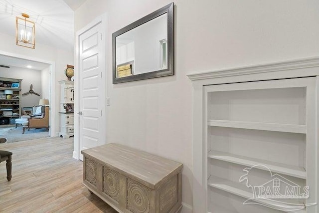 corridor with a chandelier and light hardwood / wood-style floors