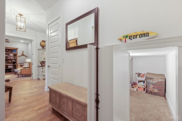 corridor featuring a notable chandelier and light wood-type flooring