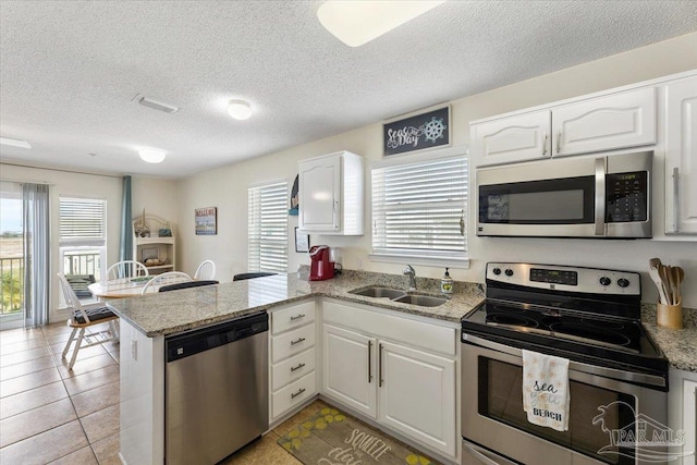 kitchen with white cabinetry, kitchen peninsula, stainless steel appliances, and sink