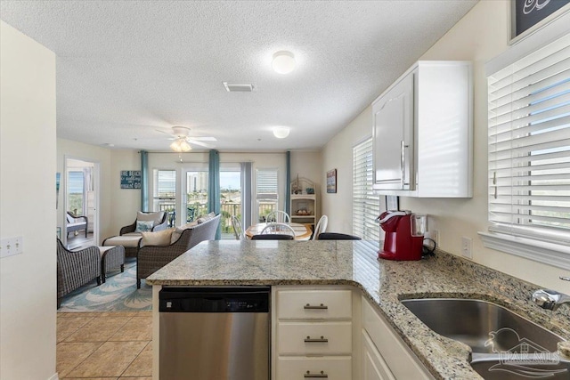 kitchen with white cabinets, a healthy amount of sunlight, and stainless steel dishwasher