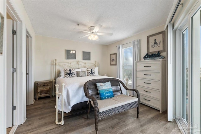 bedroom with hardwood / wood-style flooring, ceiling fan, and a textured ceiling