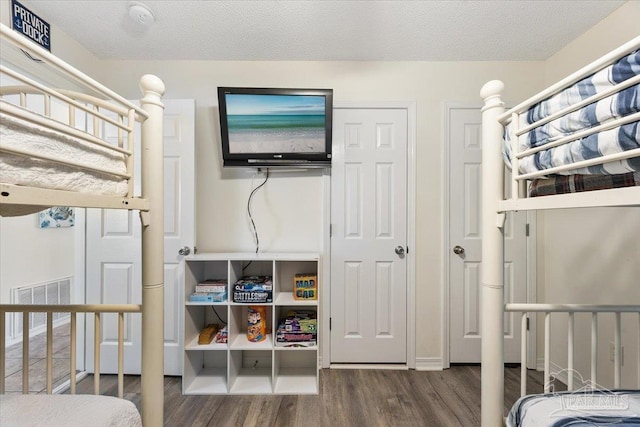 bedroom featuring wood-type flooring and a textured ceiling