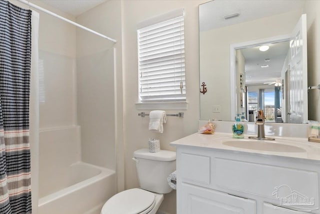 full bathroom with vanity, a textured ceiling, shower / tub combo, toilet, and ceiling fan