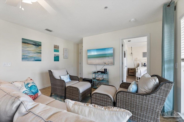 living room with a textured ceiling and ceiling fan