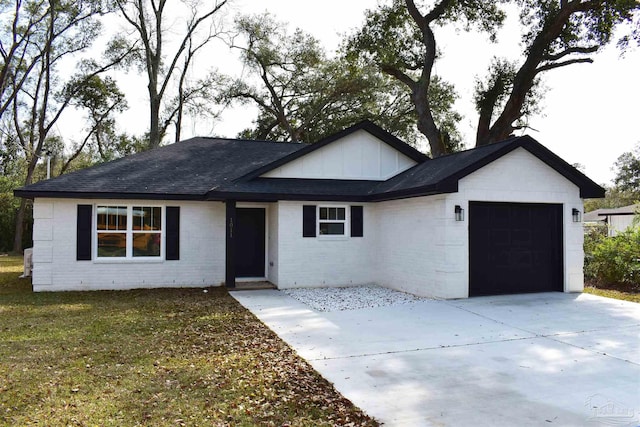 single story home with a front yard, an attached garage, a shingled roof, concrete driveway, and brick siding