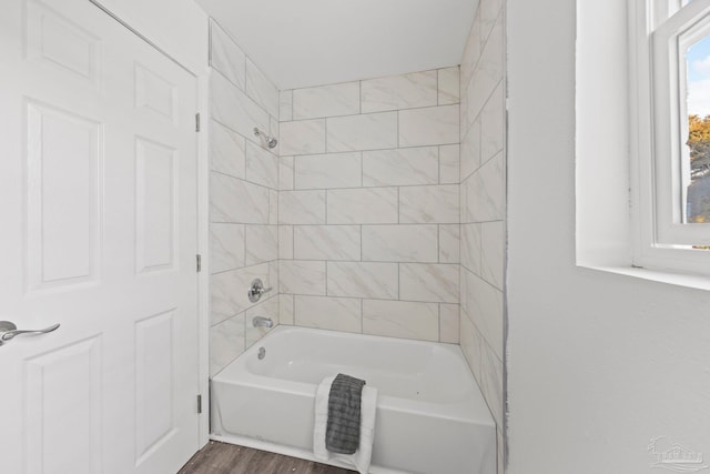 bathroom featuring wood-type flooring and tiled shower / bath