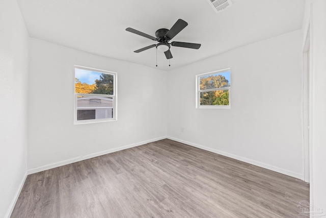 unfurnished room with a wealth of natural light, ceiling fan, and hardwood / wood-style flooring