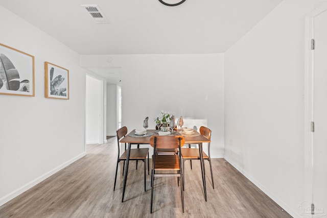 dining space with hardwood / wood-style floors