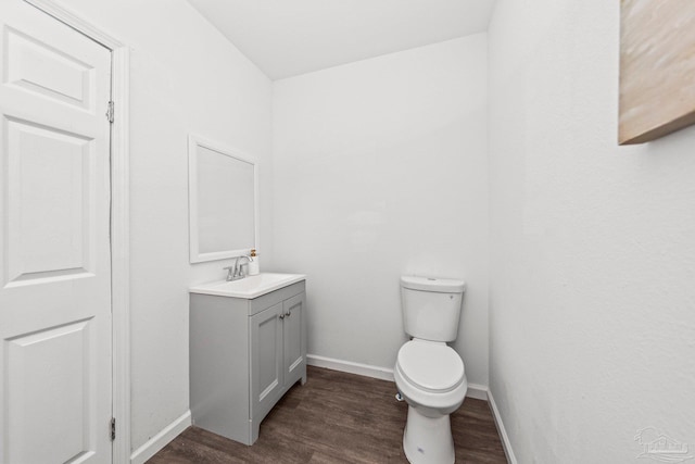 bathroom with hardwood / wood-style floors, vanity, and toilet