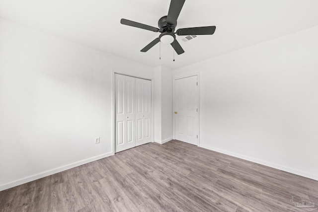 unfurnished bedroom featuring a closet, light hardwood / wood-style flooring, and ceiling fan