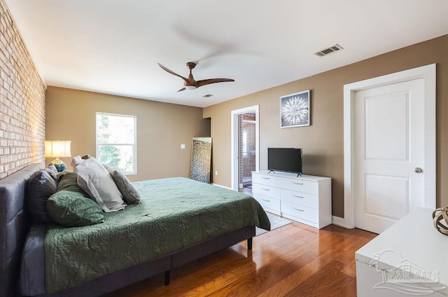 bedroom with ensuite bath, ceiling fan, and hardwood / wood-style floors