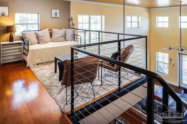 interior space featuring hardwood / wood-style floors, crown molding, and multiple windows