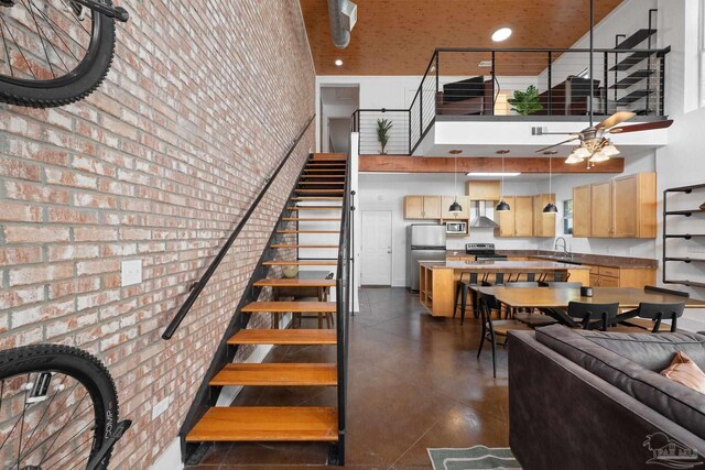 rear view of property with a balcony, a garage, and central AC unit