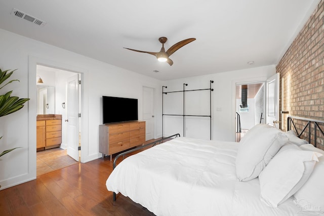 bedroom with ensuite bath, ceiling fan, and hardwood / wood-style floors