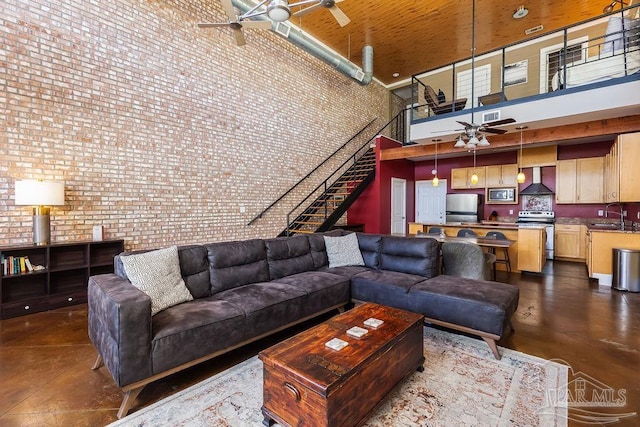 living room with sink, brick wall, and a high ceiling