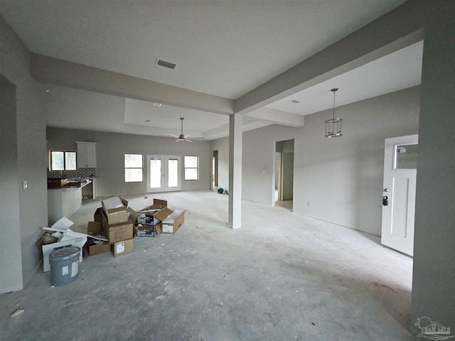 unfurnished living room featuring a tray ceiling and ceiling fan