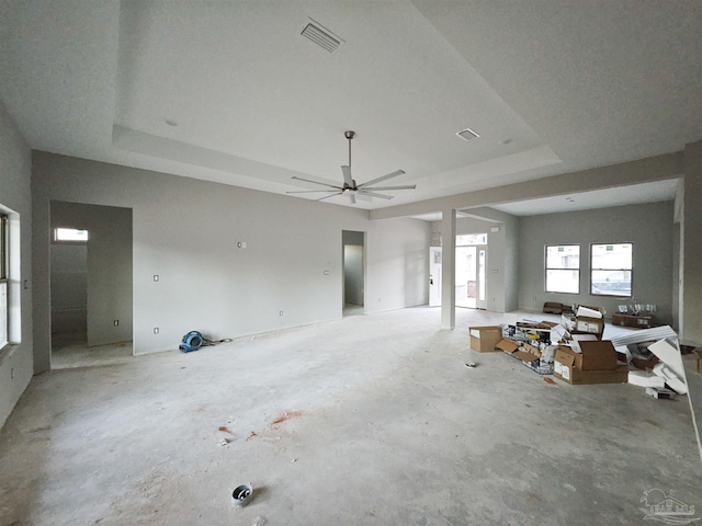 interior space featuring a raised ceiling and ceiling fan