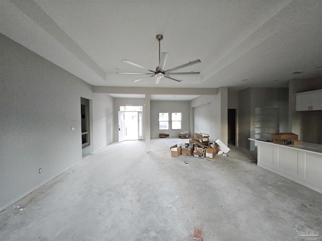 unfurnished living room with ceiling fan and concrete floors