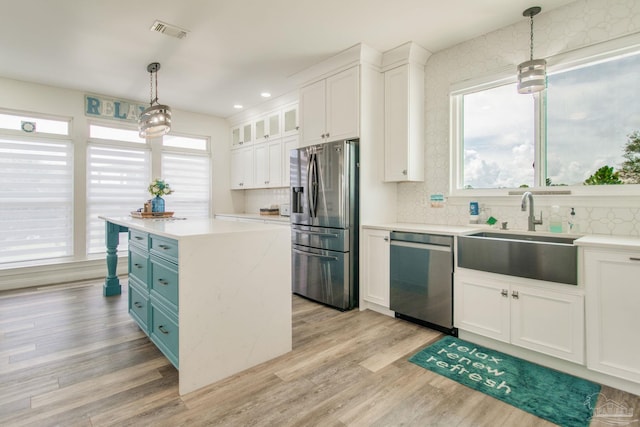 kitchen with stainless steel appliances, sink, light wood-type flooring, and tasteful backsplash