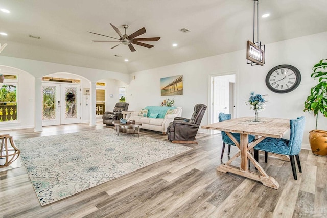 living room with visible vents, arched walkways, light wood-style flooring, french doors, and recessed lighting