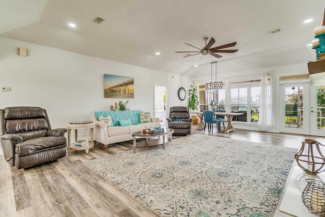 living area featuring ceiling fan, wood finished floors, visible vents, and lofted ceiling