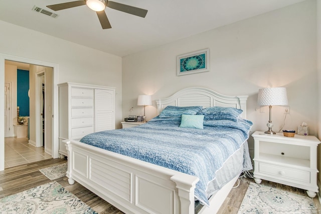 bedroom with baseboards, visible vents, a ceiling fan, wood finished floors, and a closet