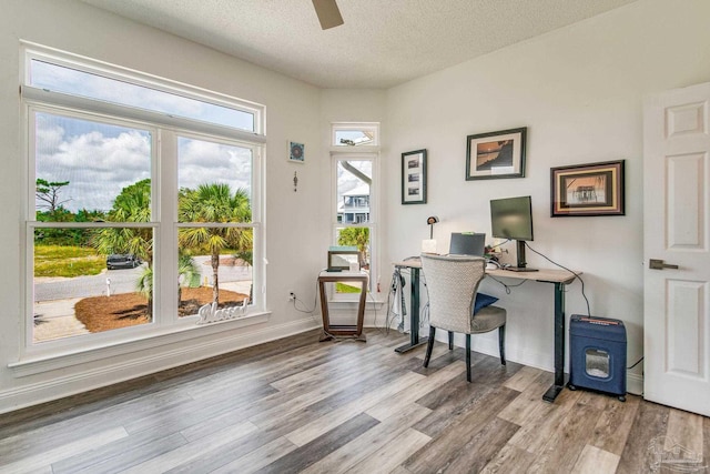 office space featuring a textured ceiling, wood finished floors, a ceiling fan, and baseboards